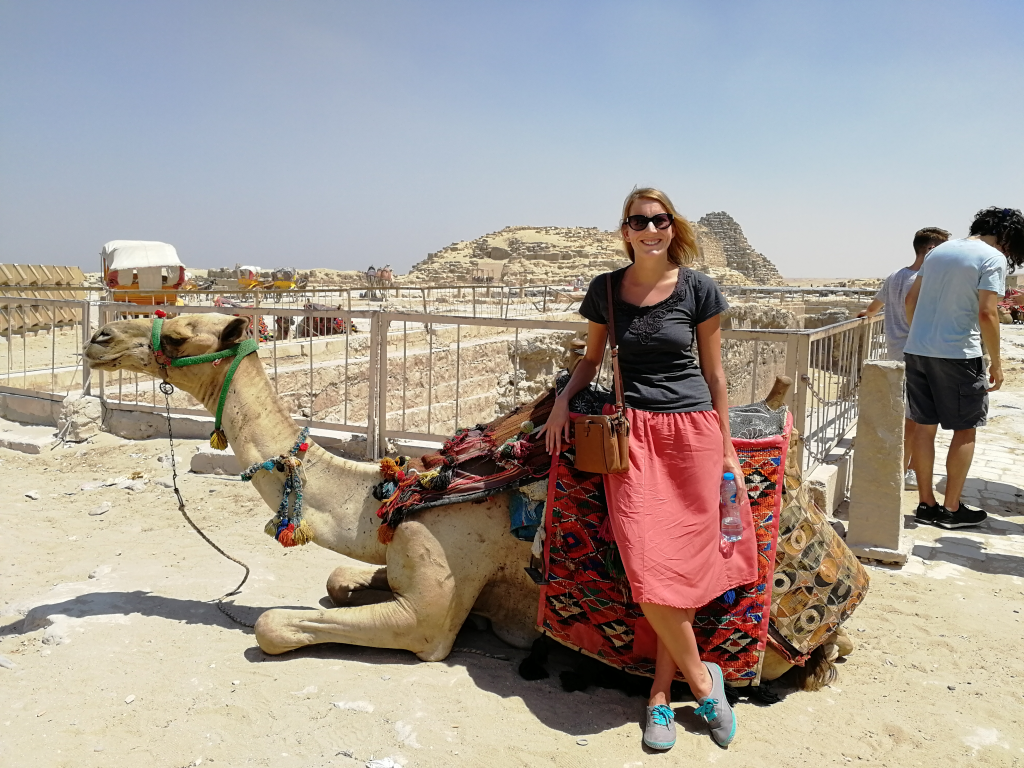 woman standing next to camel in Giza, Egypt